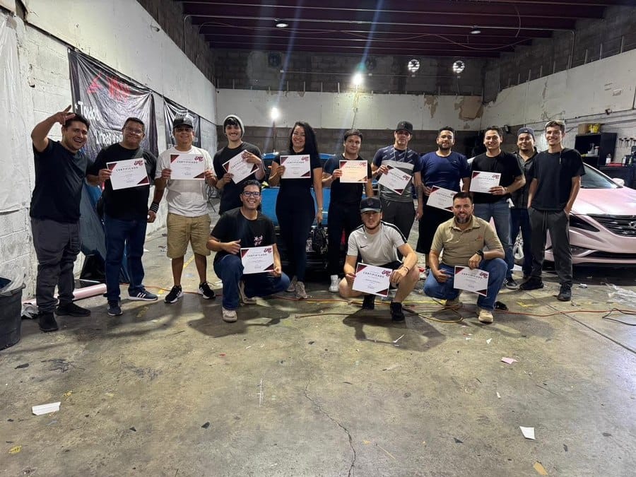 Grupo de egresados mostrando sus certificados de la Escuela de Wrap