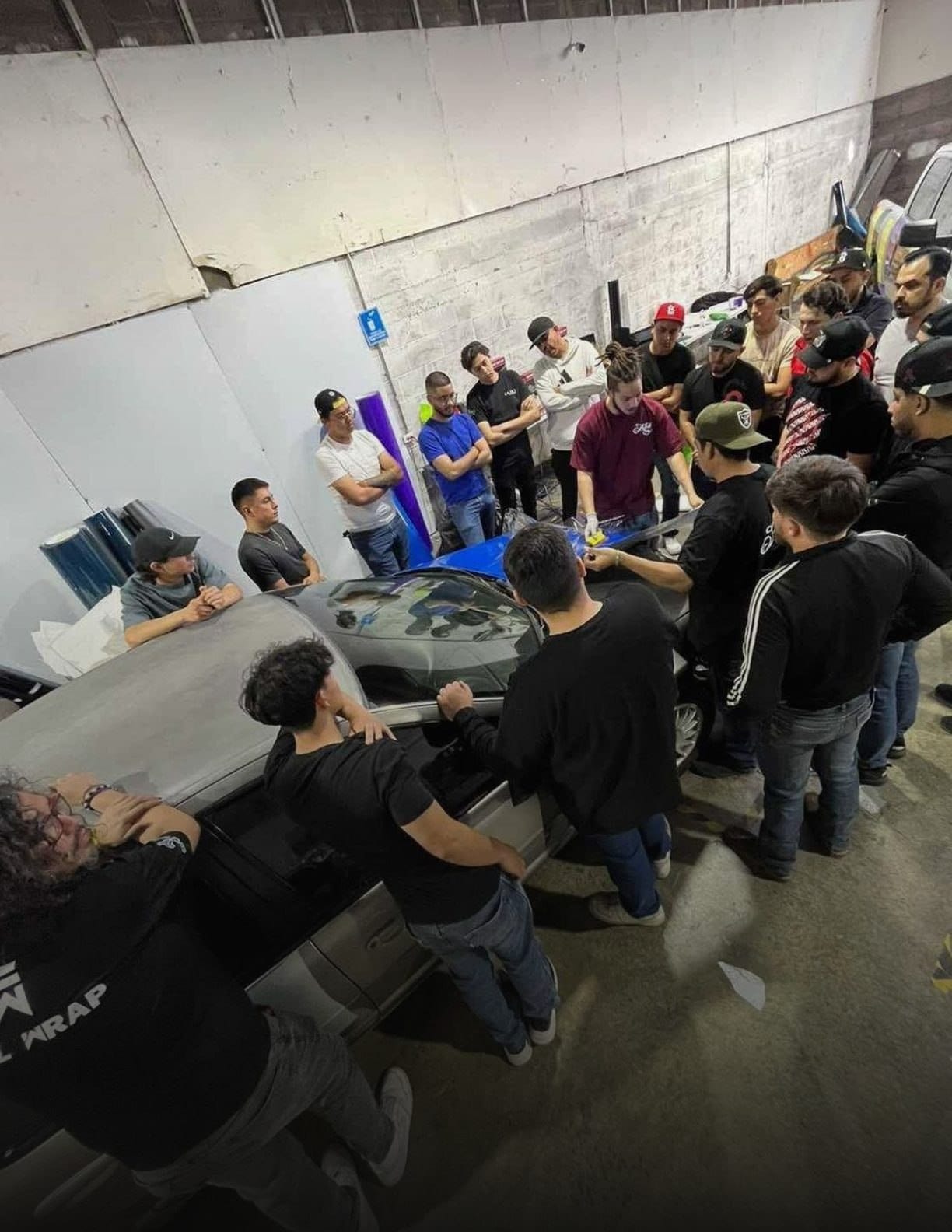 Grupo de alumnos aprendiendo instalación de wrap en el taller de Auto Tuning Shop