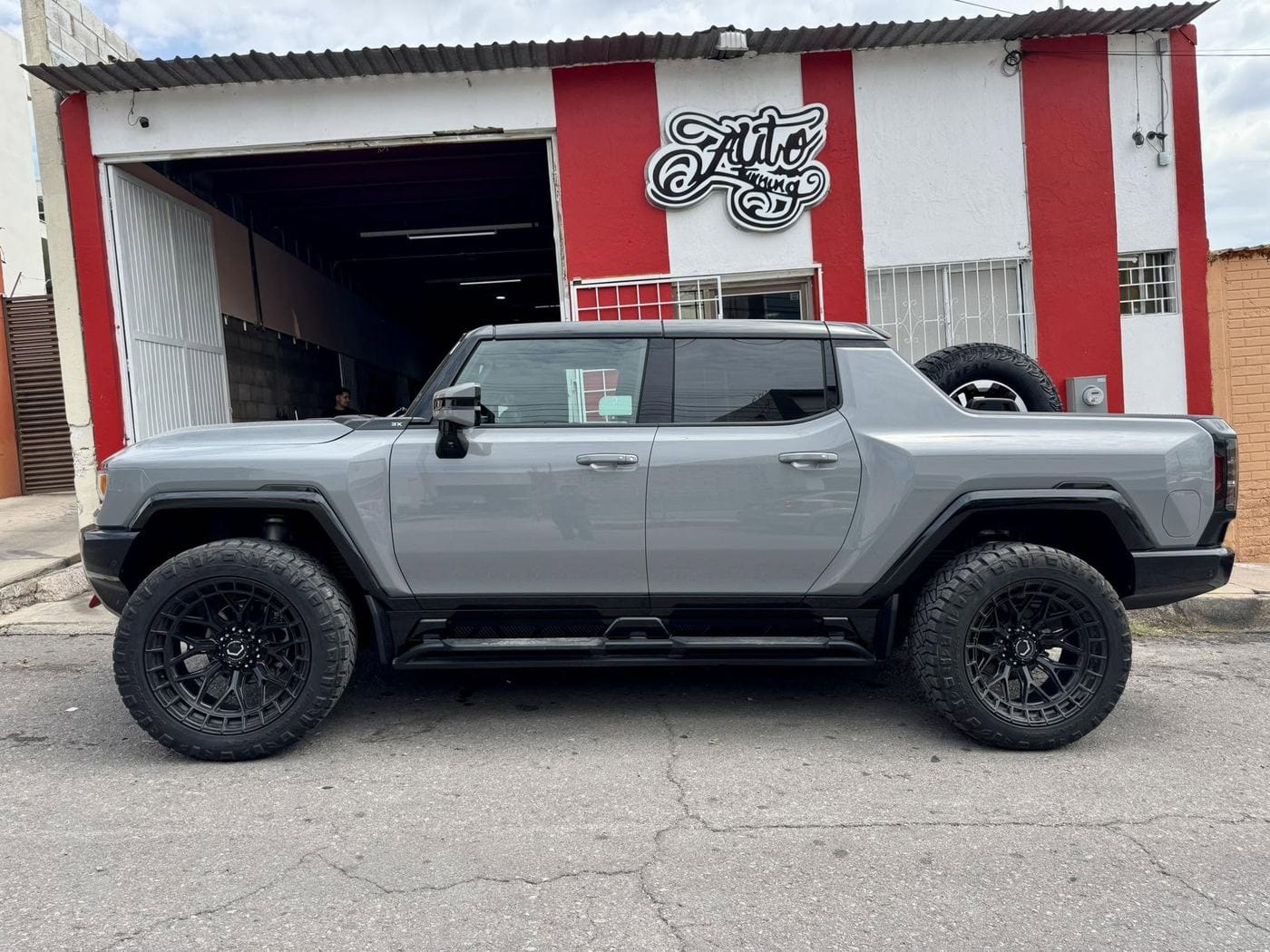 GMC Hummer EV gris afuera de Auto Tuning Shop